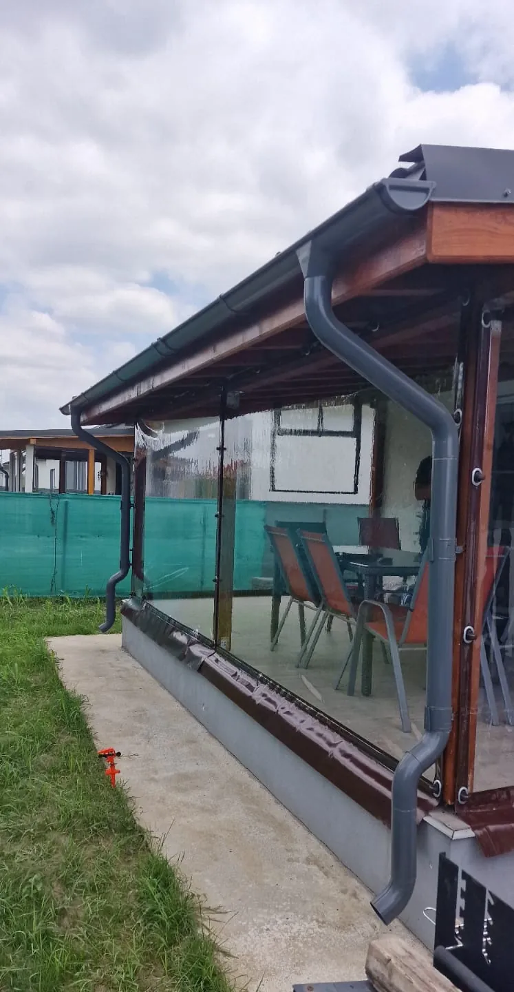 Terasă închisă cu folie cristal transparentă prinsă cu capse și bride