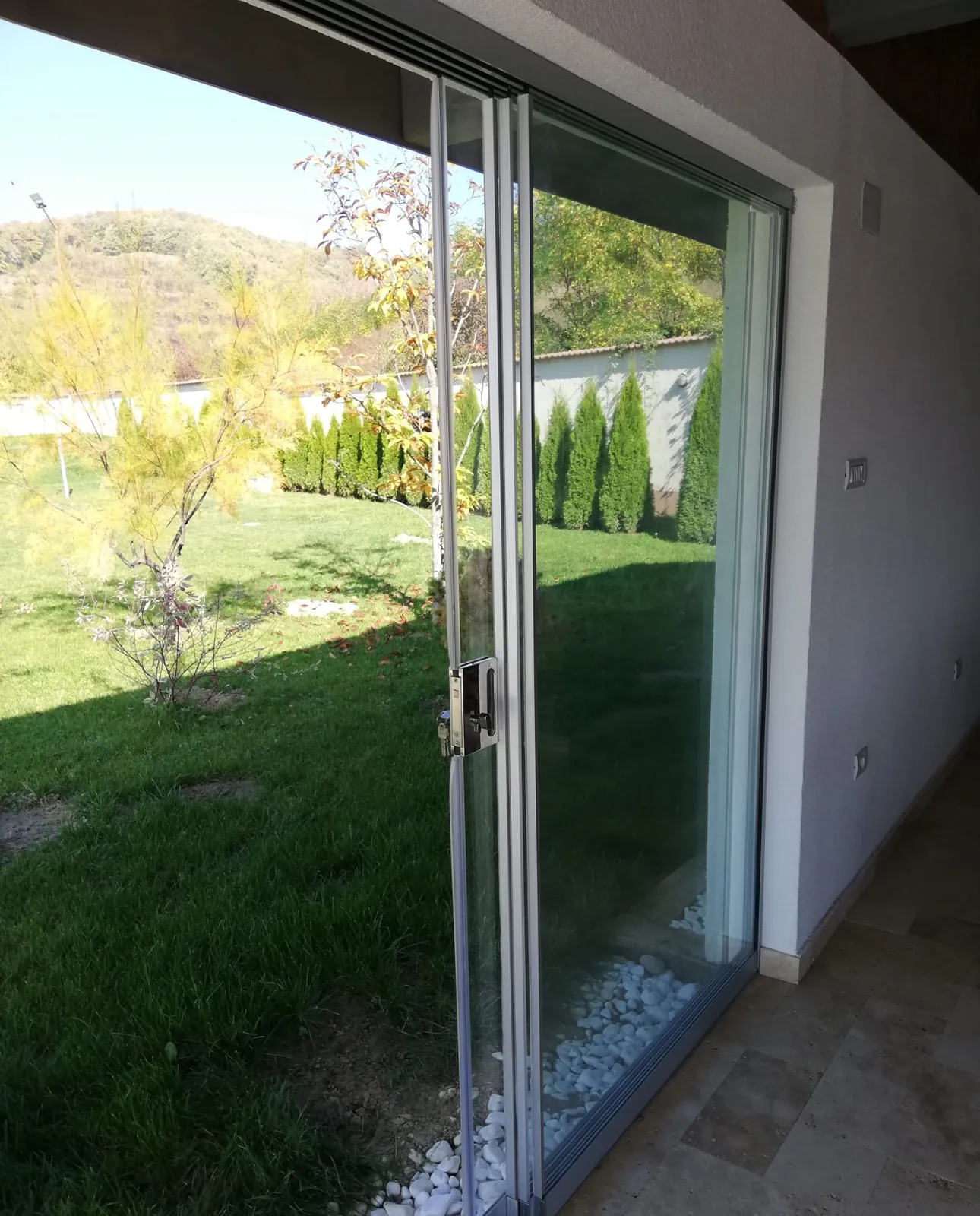 Terasă închisă cu panouri de sticlă securizată pe sistem pliabil